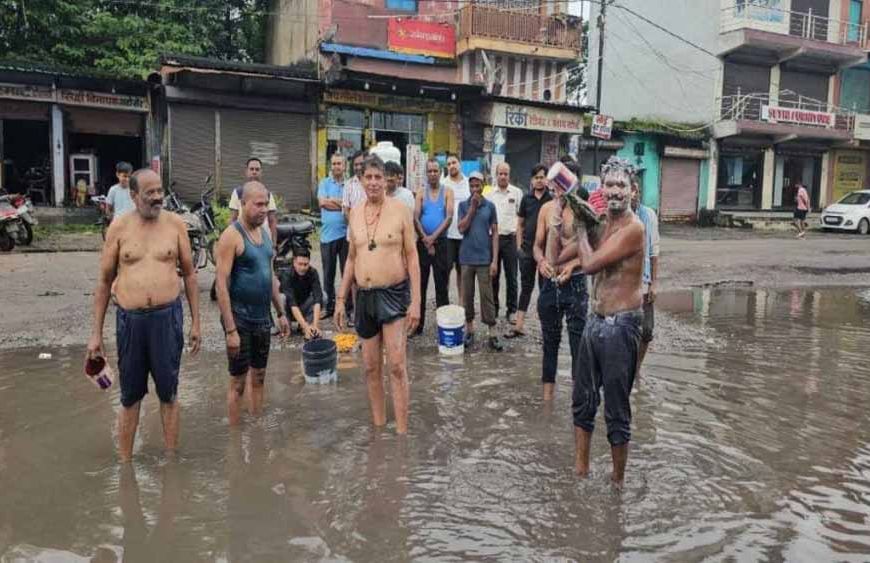 जगह-जगह गड्ढों से त्रस्त व्यापारी, पानी से भरे गड्ढों में नहा कर जताया विरोध
