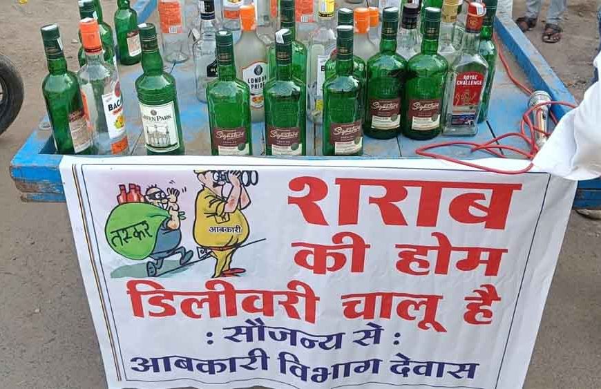 ठेले पर सजी शराब की बोतलें, पोस्टर में लिखा– ‘होम डिलीवरी चालू है’; देवास में कांग्रेस का अनोखा विरोध प्रदर्शन